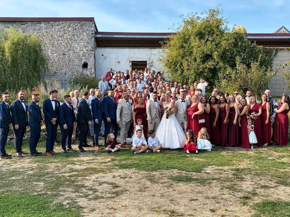 Photo de groupe des invités d'un mariage dans la cour du domaine