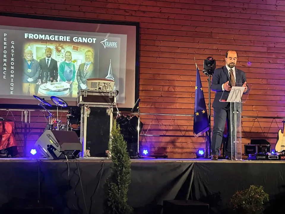 Discours au pupitre lors d'une soirée de gala, projection sur grand écran