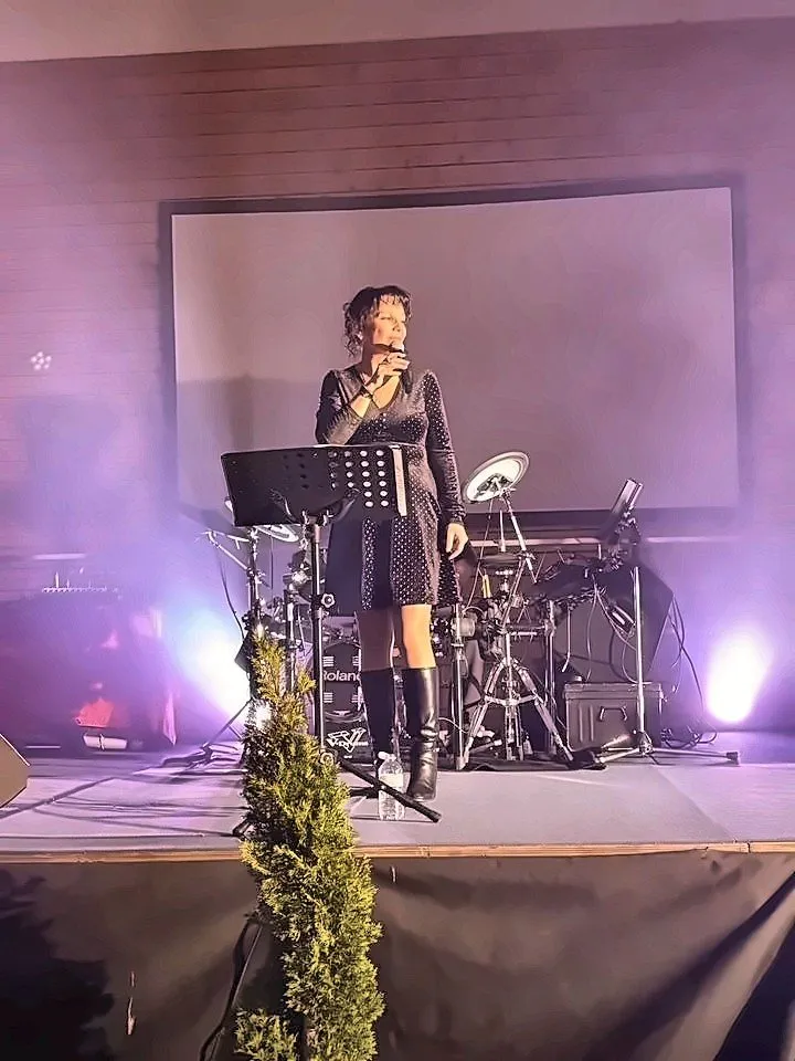 Chanteuse au micro sur une scène éclairée