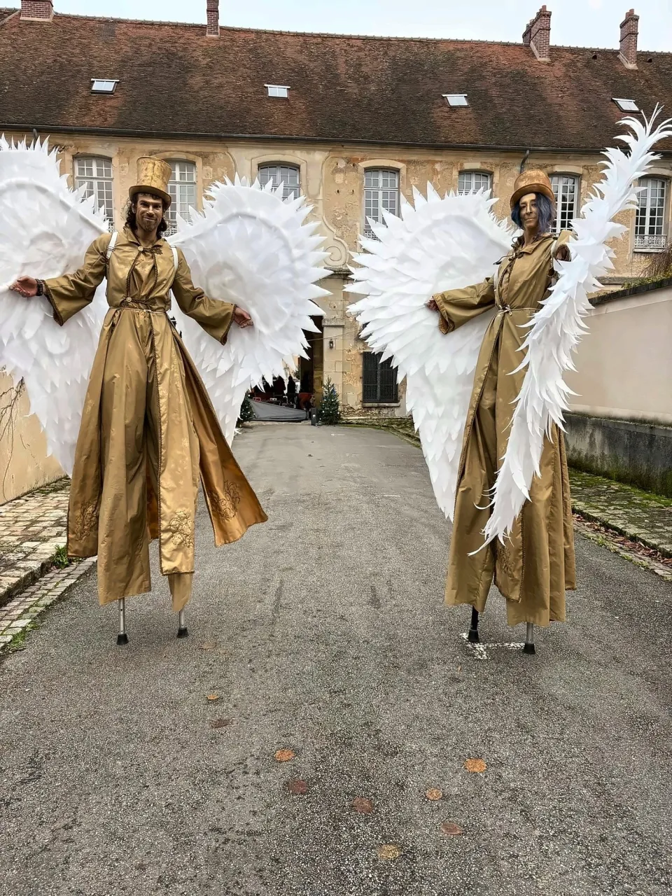 Échassiers en anges dorés dans une cour pavée