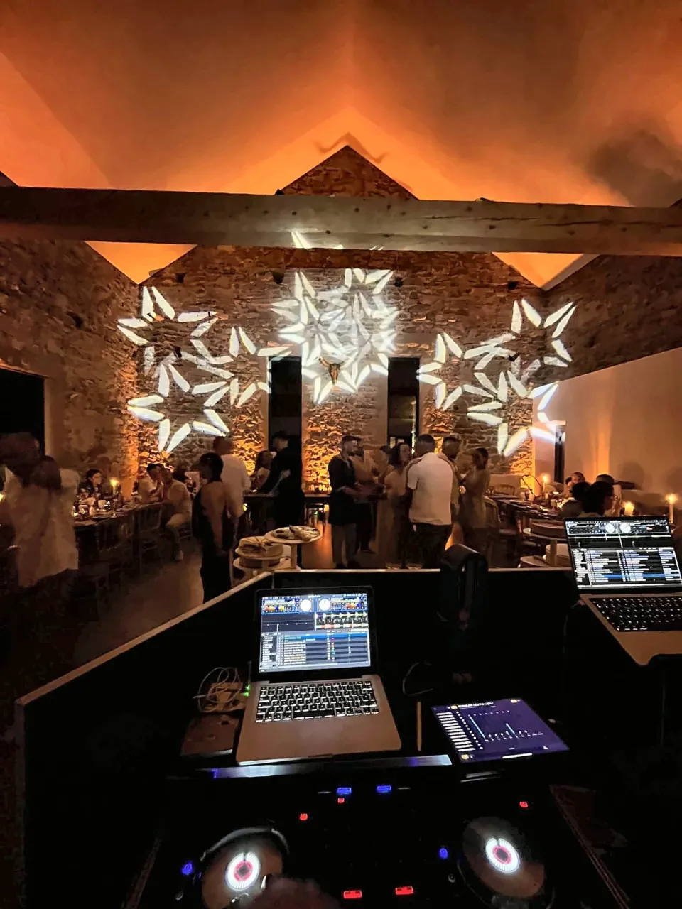 Régie du DJ face à un mur de pierre illuminé d'étoiles